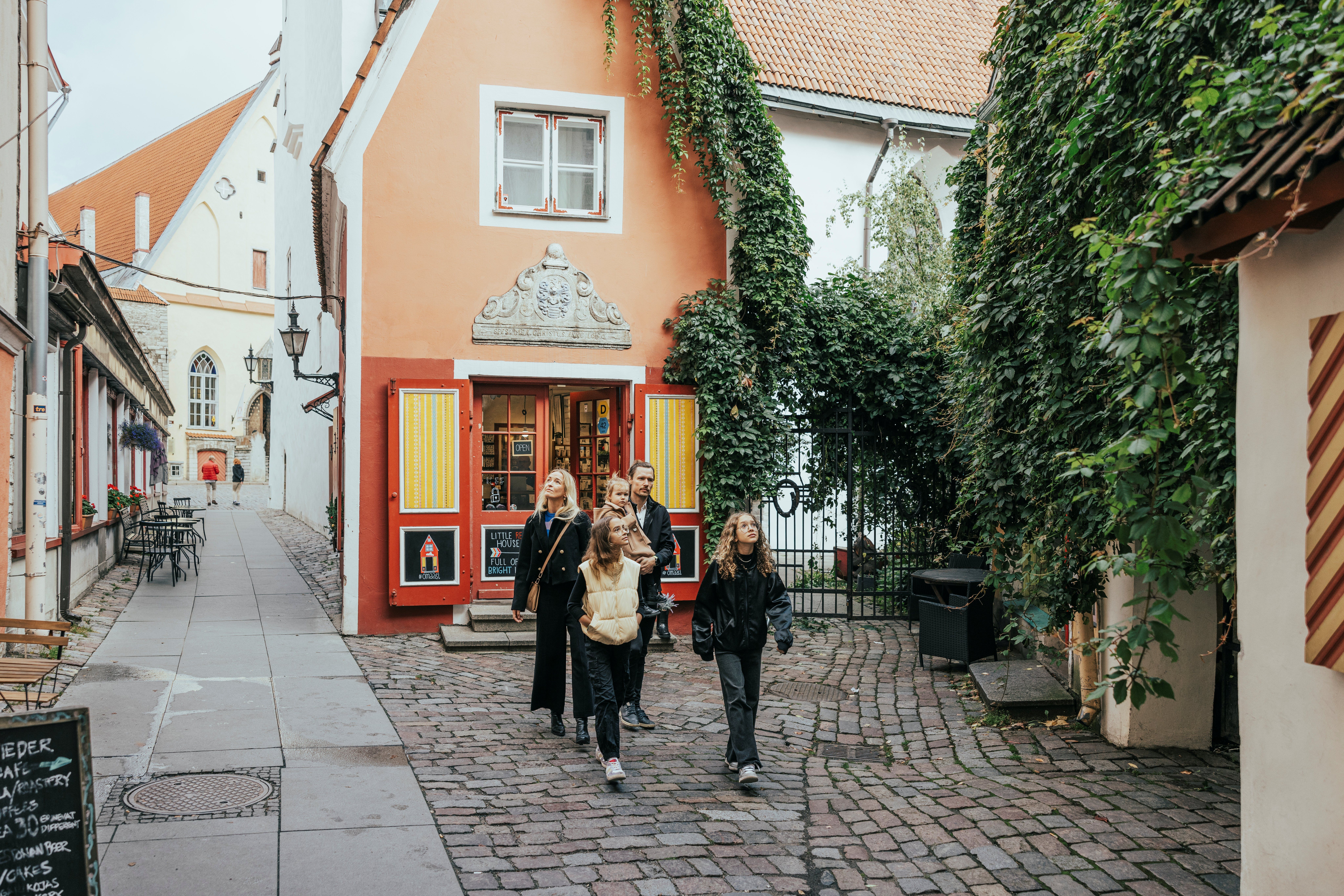 Pere jalutab Tallinna vanalinna munakivit&auml;naval v&auml;rviliste majade ja ronitaimedega kaetud hoonete vahel