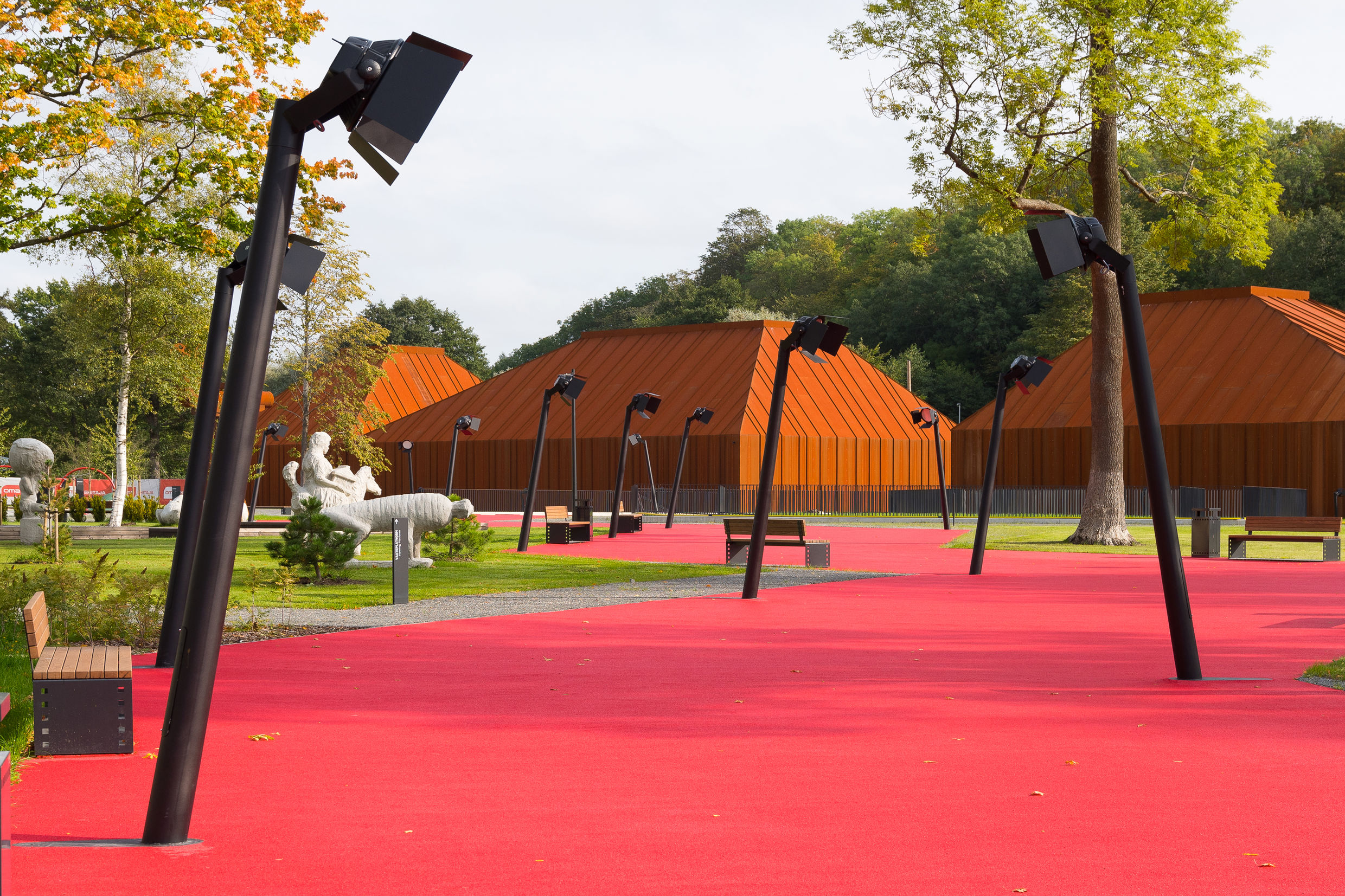 Vaade Eesti Filmimuuseumi esisele pargile, esiplaanil valguskaameratega ääristatud punane rada