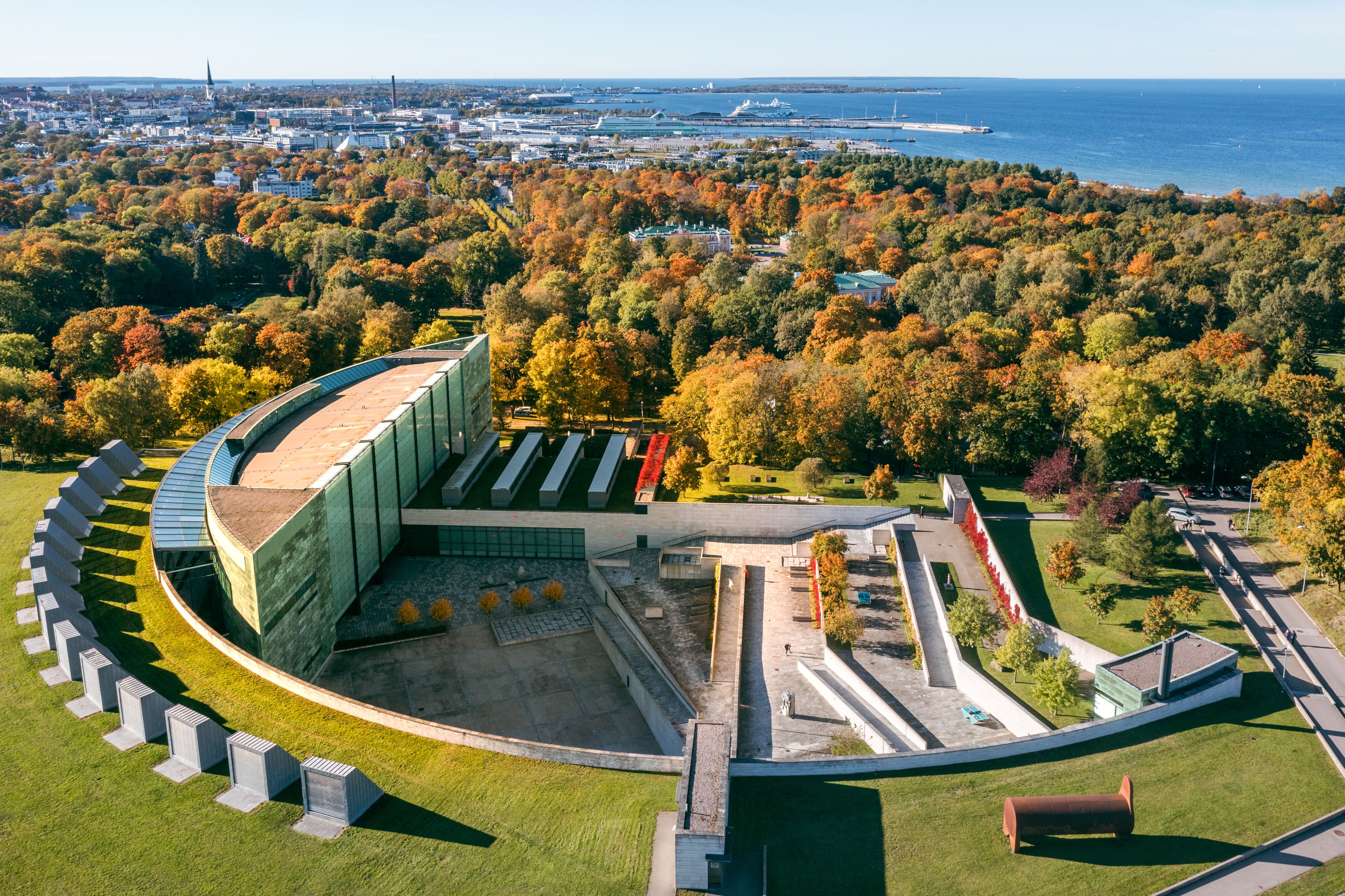Aerial view of Kumu Art Museum in Kadriorg surrounded by autumn park and view to Tallinn Bay.