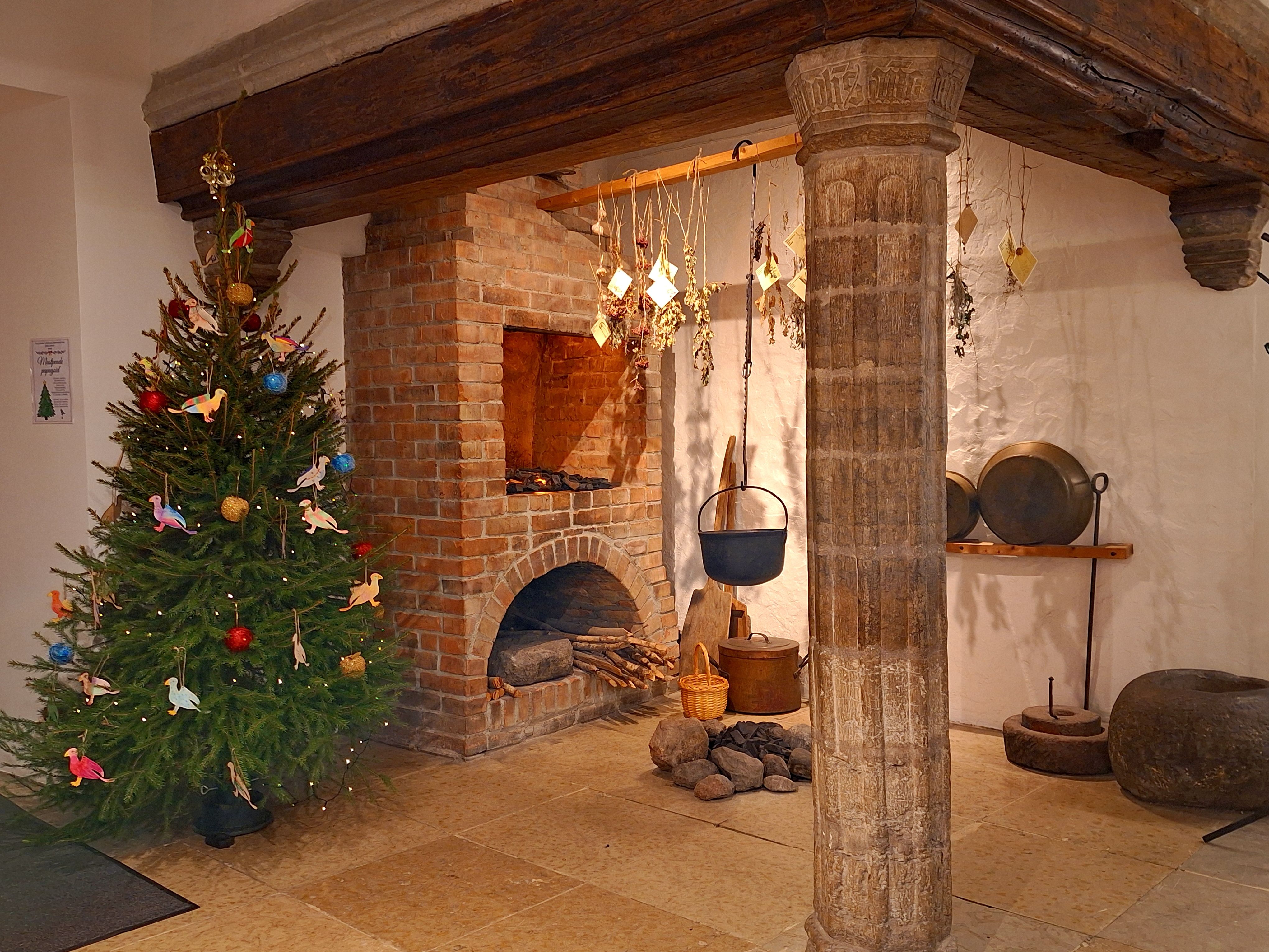 Tallinna Linnaelumuuseumi j&otilde;ulupuu v&auml;rviliste &otilde;unte ja papagoidega vana telliskamina k&otilde;rval ajaloolises toas.