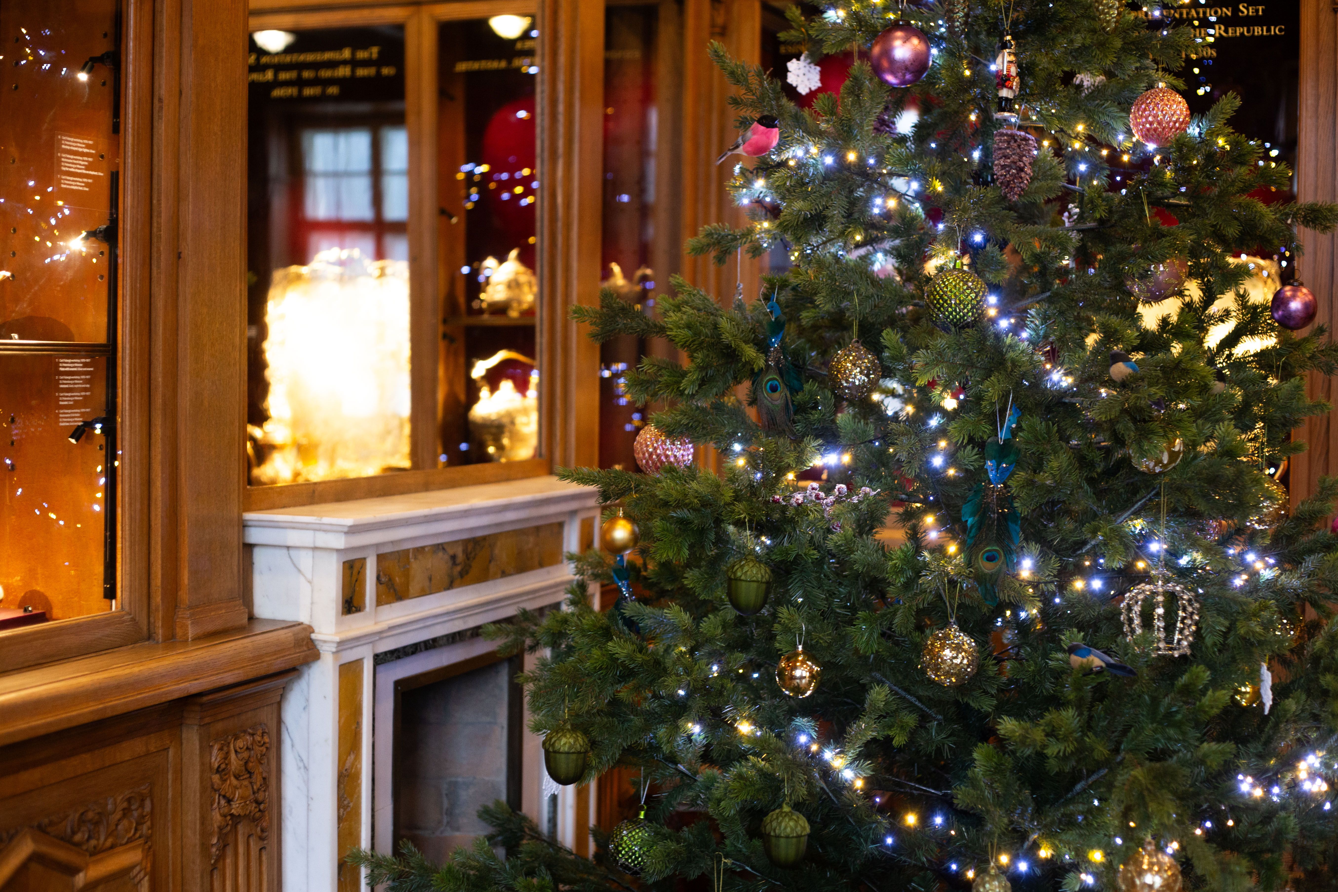 Kadrioru kunstimuuseumi jõulupuu Pähklipureja teemaliste ehetega, säravate tulede ja rikkaliku puidust muuseumiinterjööri taustal.