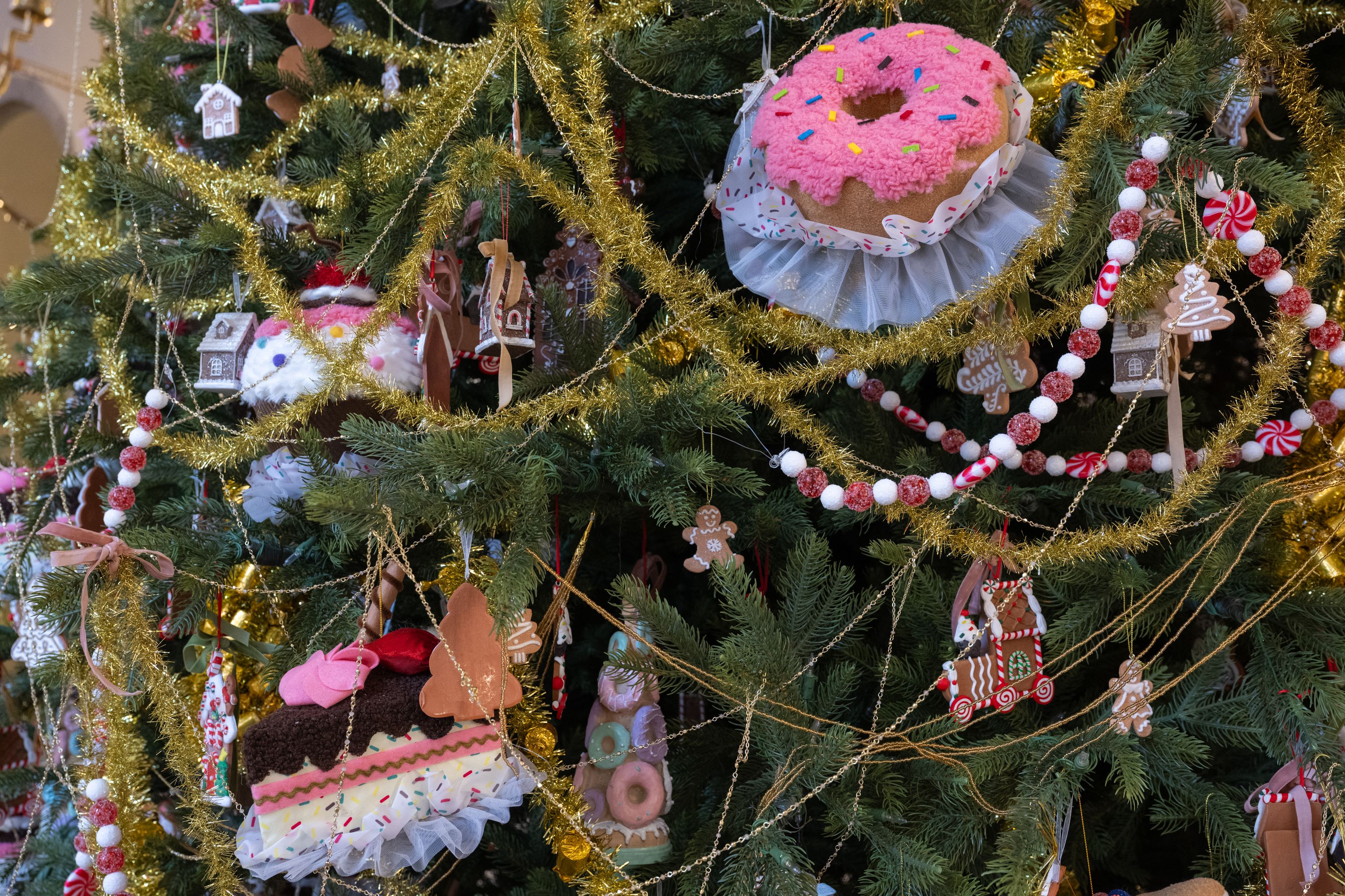 Niguliste muuseumi jõulukuusk, kaunistatud roosade sõõrikute, piparkoogimajakeste ja kuldsete vanikutega, lähedalt vaadatuna.