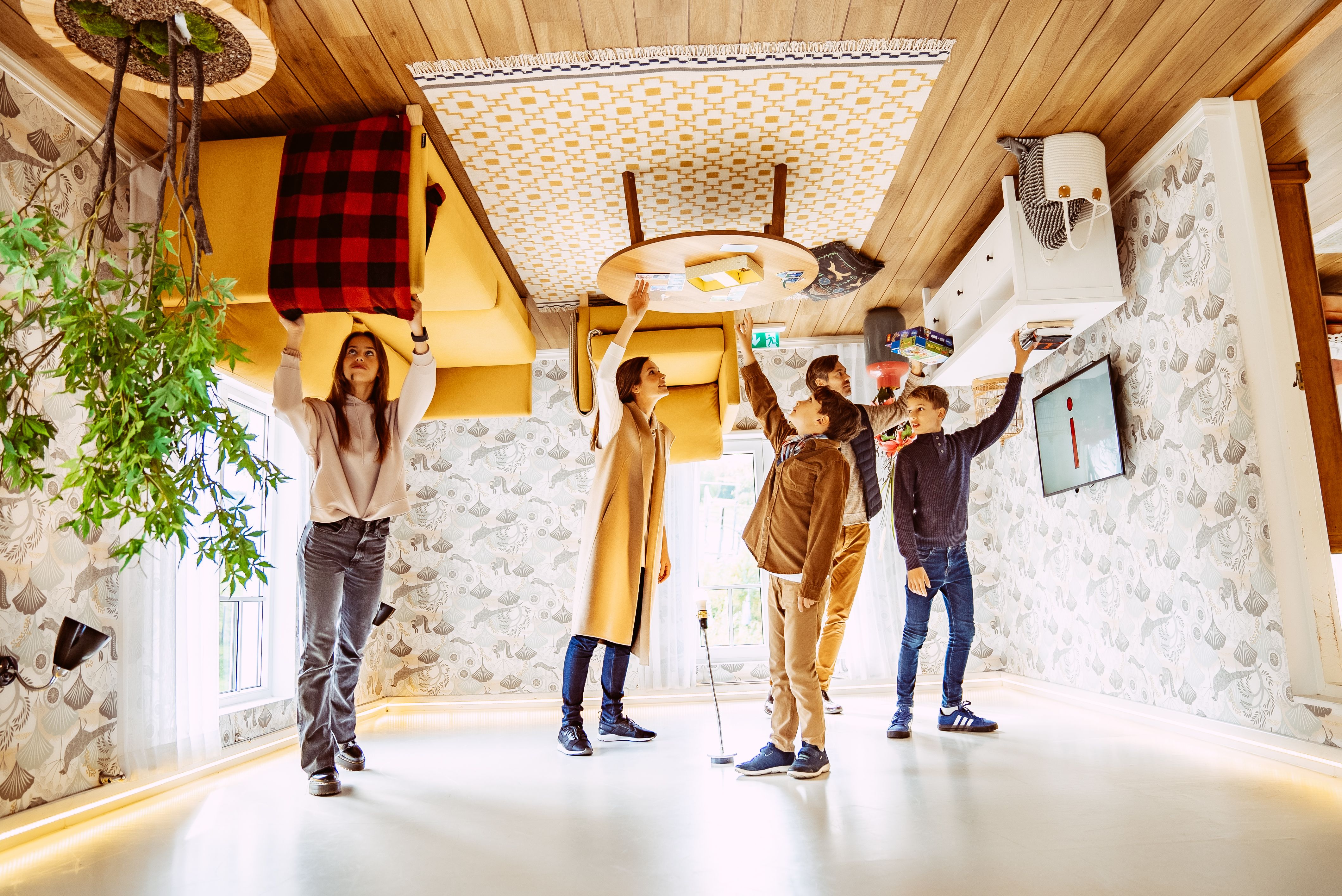 A family of five looking around inside the Upside Down House in Tartu