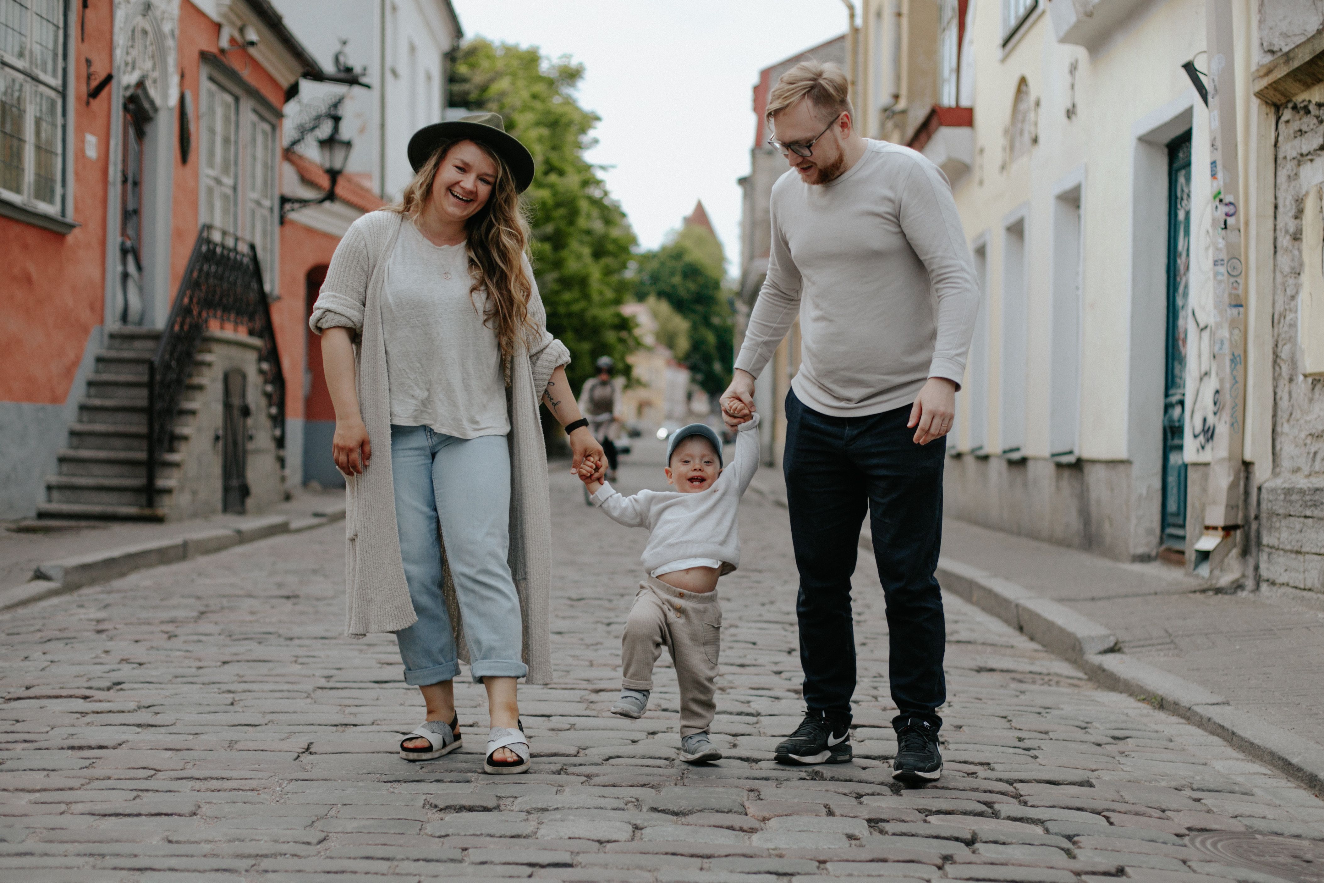 Isä, äiti ja pieni poika kävelemässä Tallinnan keskiaikaisessa vanhassakaupungissa