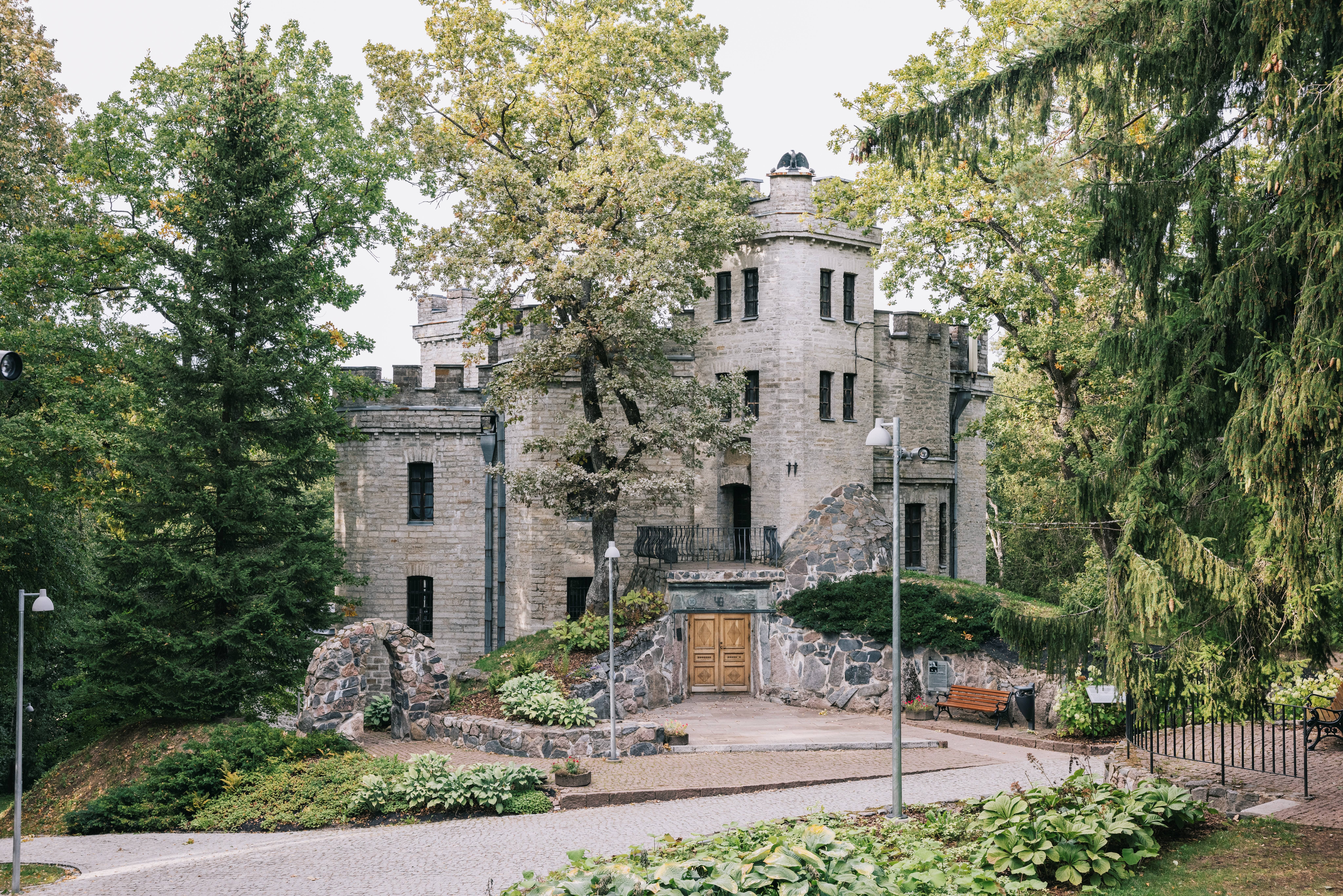 View of Glehni Castle, a stone fortress-like building surrounded by trees and greenery in the Nõmme district of Tallinn.