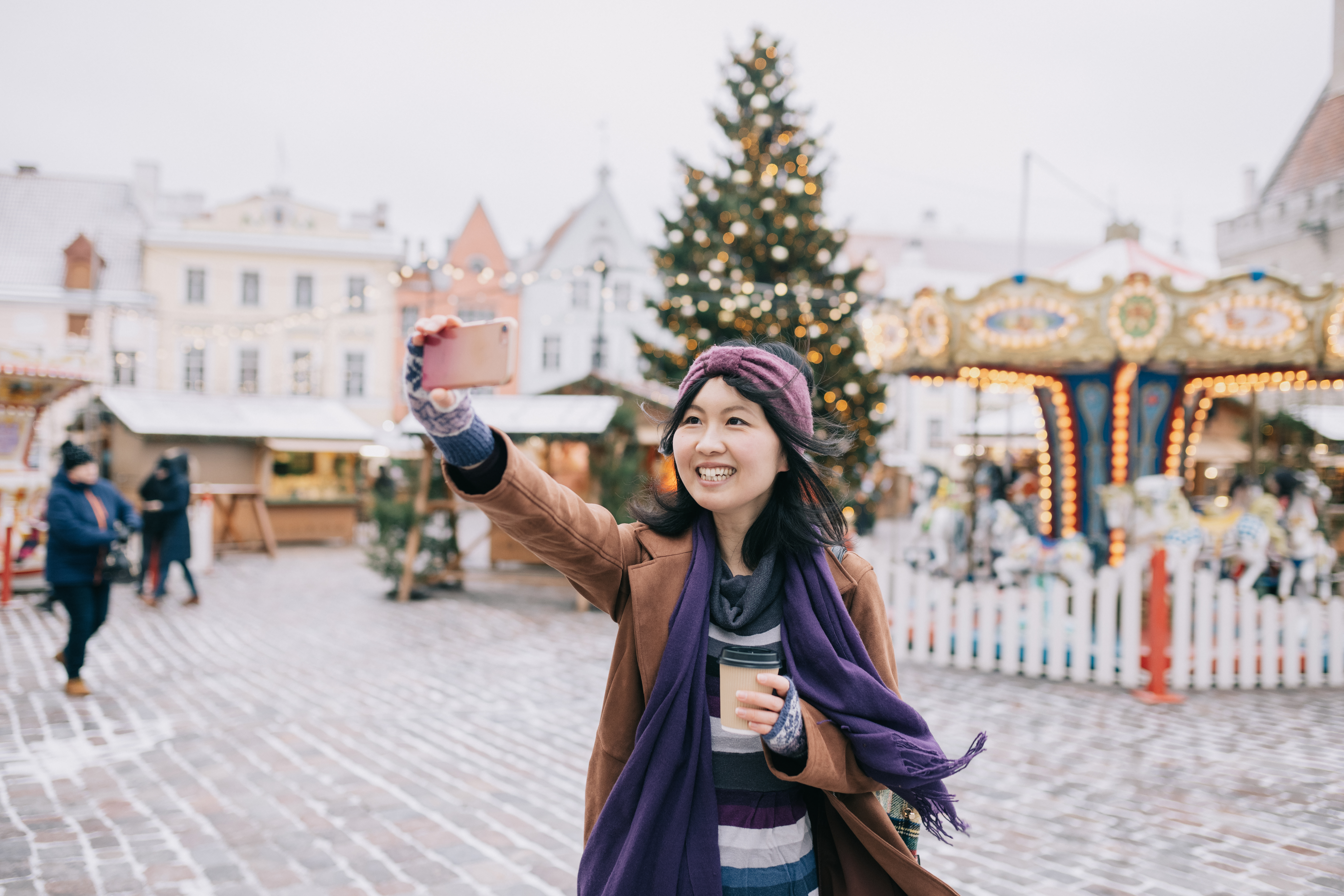 Smiling woman taking selfie at Tallinn Christmas Market, Estonia