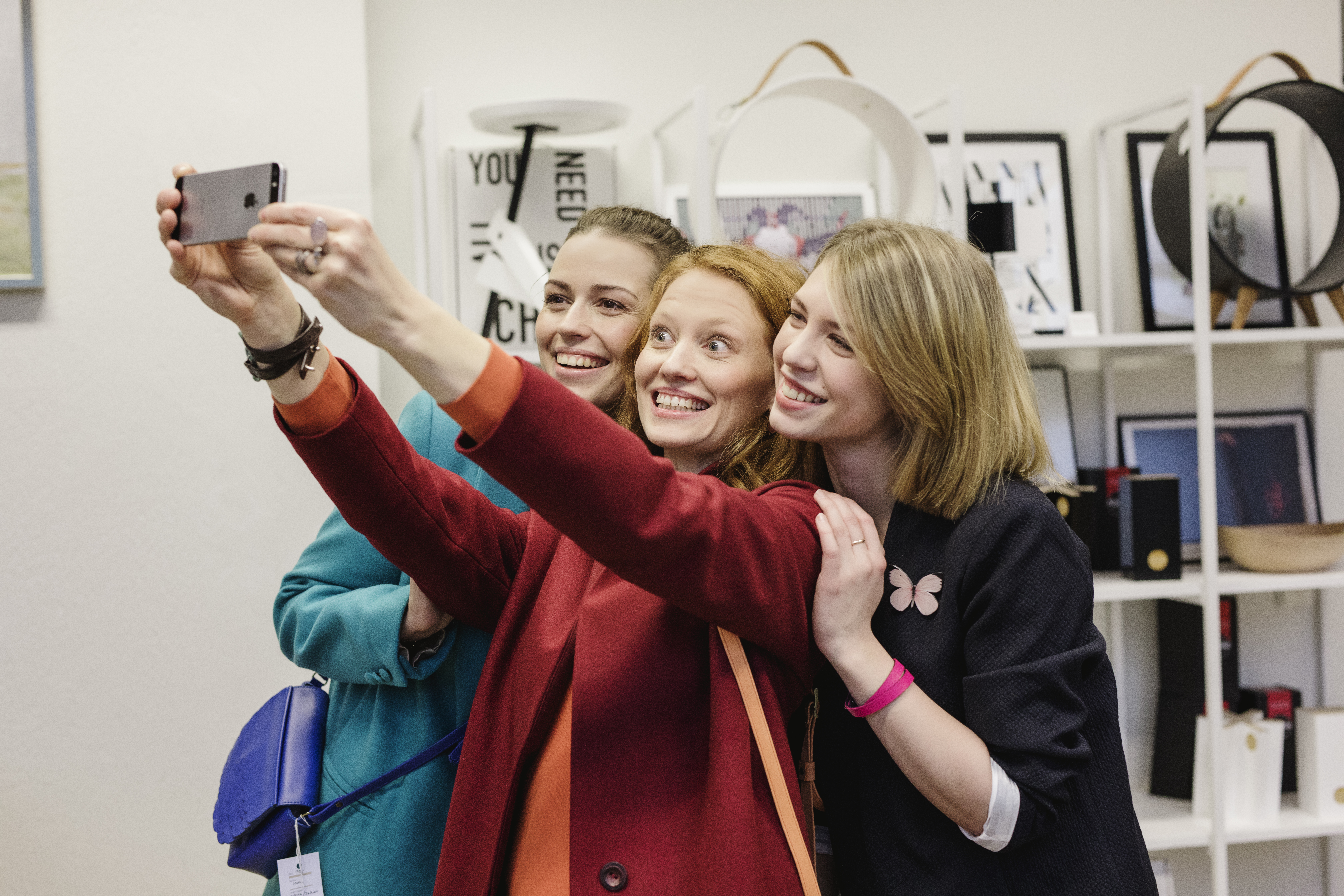 Drei Freunde machen ein lustiges Selfie in einem Designgeschäft in Tallinn, Estland.